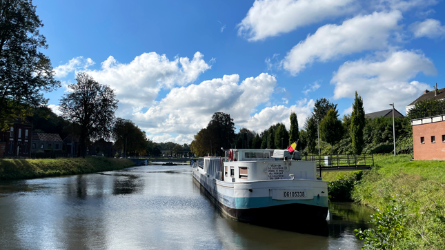 péniche à l'arrêt sur un canal d'eau artisanal sous un ciel bleu