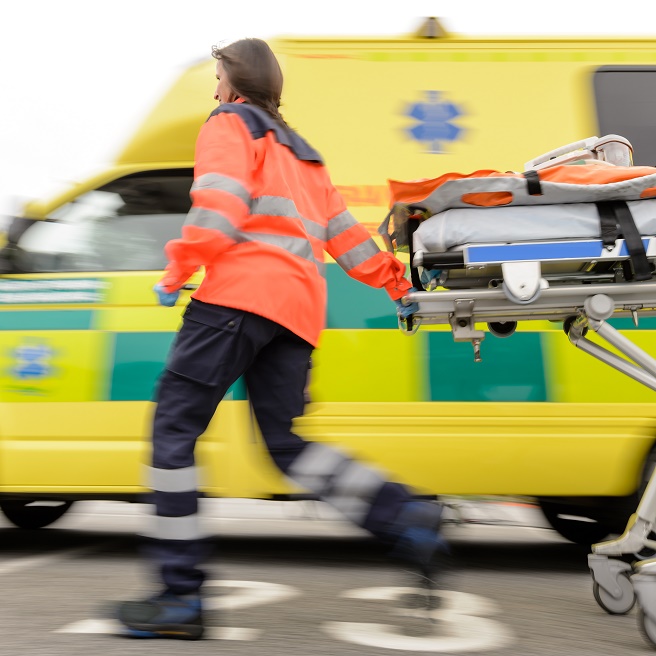 Running blurry paramedic woman rolling stretcher outside of ambulance car